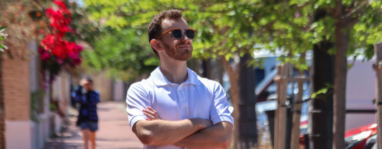 Man wearing white looking up on a street