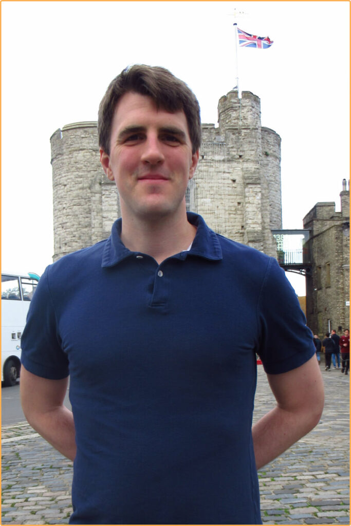 Man in Polo shirt standing in front of a castle in York, UK
