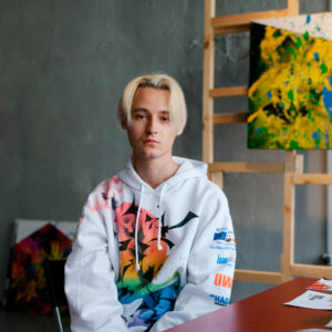 The artist Daniil Danet sitting in an atelier